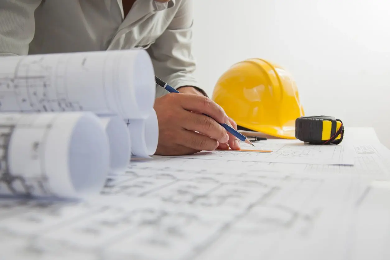 A person with a hard hat and some plans