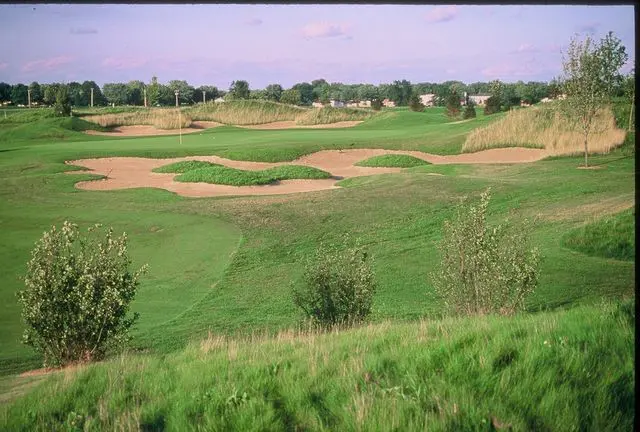 A view of a golf course with green grass.