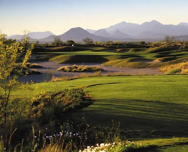 A golf course with mountains in the background.