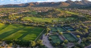 A view of some tennis courts and mountains.