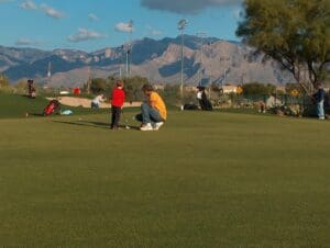 A couple of people are playing frisbee in the grass