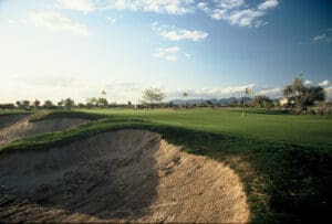 A view of a golf course with sand and dirt.