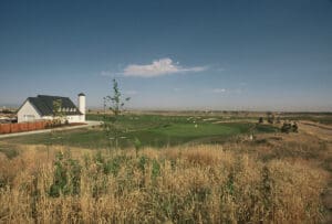 A large field with some grass and a barn